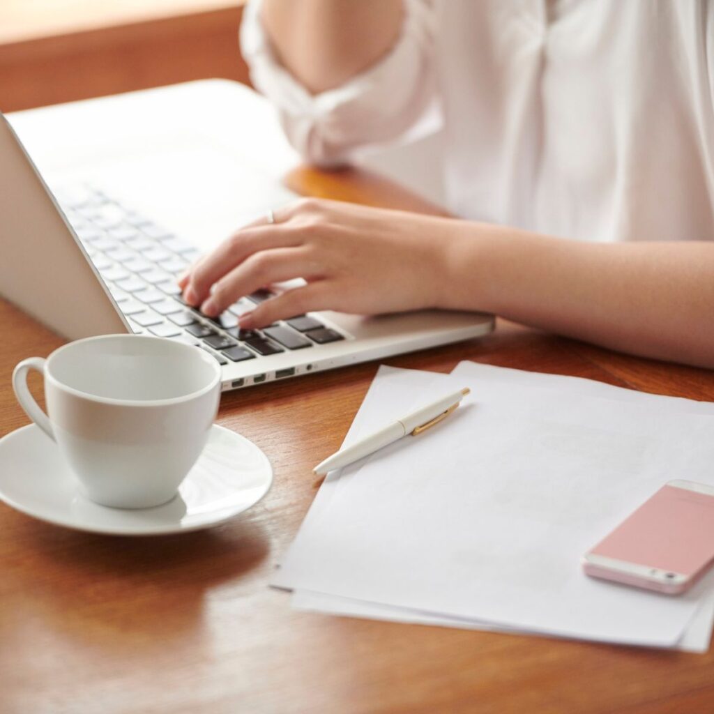 woman typing; typing on laptop; pink phone; blogging tips; how to start a blog; tips for bloggers;